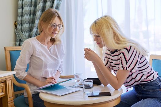 Female psychologist working with sad upset teenage girl, session in office. Adolescent depression, adolescent mental difficulties, professional psychological assistance, therapy, psychology