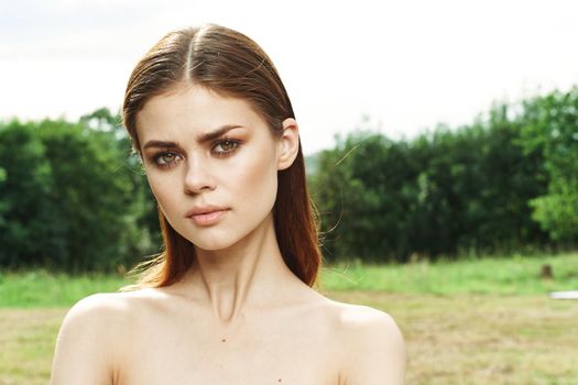 pretty woman in a field outdoors bare shoulders clear skin cropped view. High quality photo