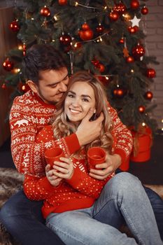 People in a Christman decorations. Man and woman in a red sweater. Family at home.