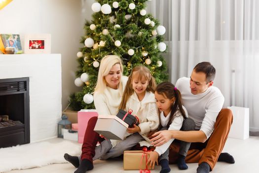 Happy family playing with Christmas gifts at home