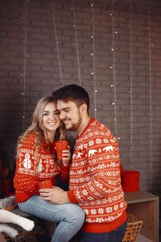 People in a Christman decorations. Man and woman in a red sweater. Family at home.
