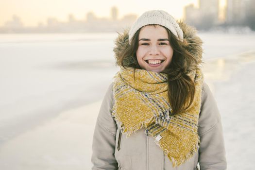 Beautiful happy laughing young woman wearing winter hat and scarf. winter background with snow. Winter holidays concept. Happy Woman In Winter Nature.