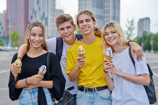 Group portrait of happy teenagers having fun with ice cream. Four smiling young people embracing together in city, lifestyle, friendship, adolescence, summer, leisure, youth concept