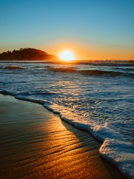 Sunrise on the beach and ocean waves on a tropical sea. High quality photo