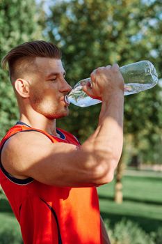 athletic man with dumbbells in his hands outdoors in the park. High quality photo