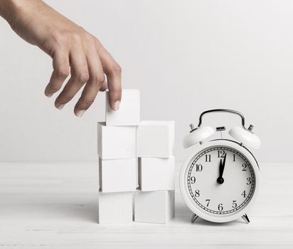 hand putting white cubes clock