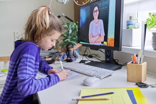 Preteen girl learning math online using home computer. A child using gadgets for learning, education and distance learning, video broadcast of lesson. Homeschooling, modern technologies in education