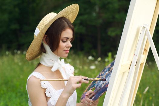 Woman in white dress outdoors artist drawing easel. High quality photo