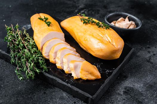 Smoked cut chicken breast fillet meat delicacy. Black background. Top view.