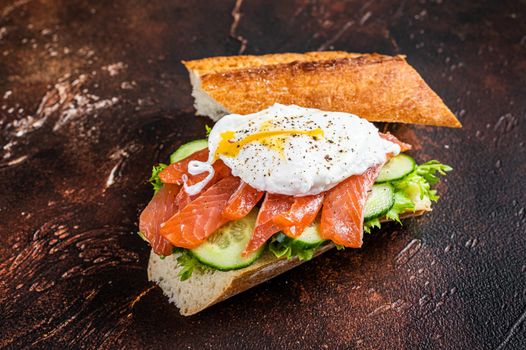 Poached egg with smoked salmon and avocado on toast. Dark background. Top view.