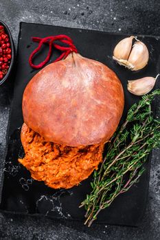 Balearic Sobrassada cured meat sausage from ground pork, paprika and spices. Black background. Top view.