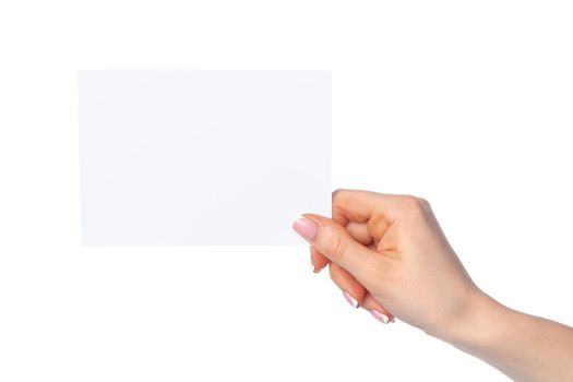 Woman's hand holding blank white sheet of paper isolated on white background