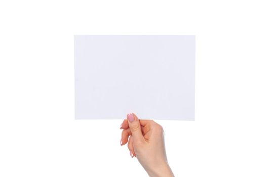 Female hand holding blank white sheet of paper isolated on white background