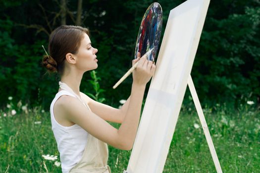 woman artist nature paints palette easel creative landscape. High quality photo
