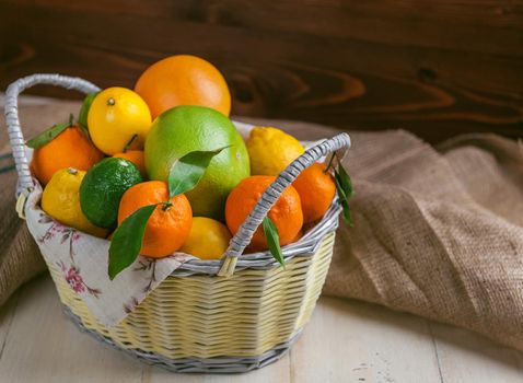 citrus fruits in a wicker basket on a wooden background