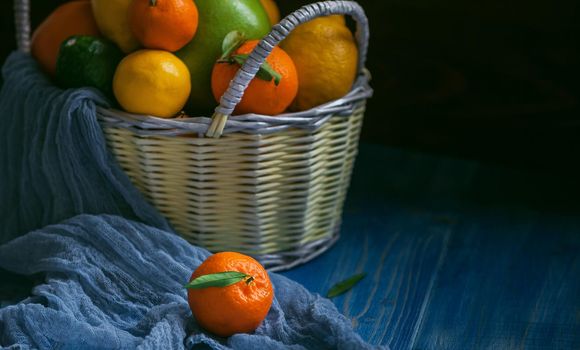 citrus fruits in a wicker basket on a wooden background