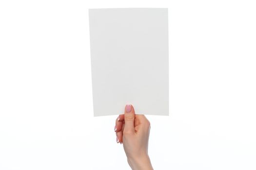 Female hand holding blank white sheet of paper isolated on white background