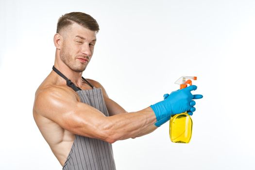 man in apron detergent cleaning service light background. High quality photo