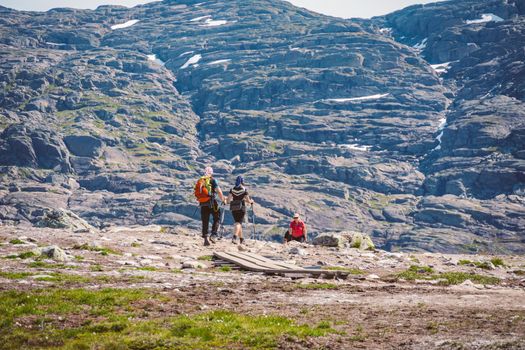 July 26, 2019. Norway tourist route on the trolltunga. People tourists go hiking in the mountains of Norway in fine sunny weather to thetrolltunga. Hiking backpack theme.