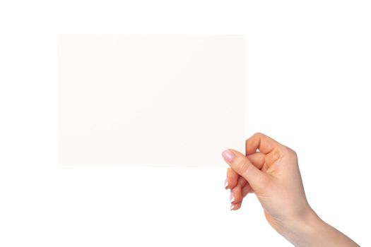 Woman's hand holding blank white sheet of paper isolated on white background