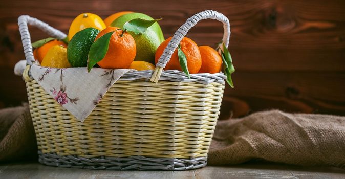 citrus fruits in a wicker basket on a wooden background