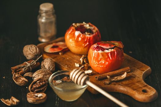 baked apples with cottage cheese with berries and nuts, topped with honey and sprinkled with cinnamon. on a wooden surface in a rustic style