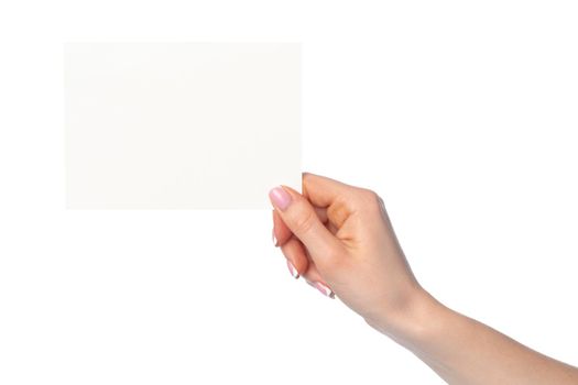 Woman's hand holding blank white sheet of paper isolated on white background