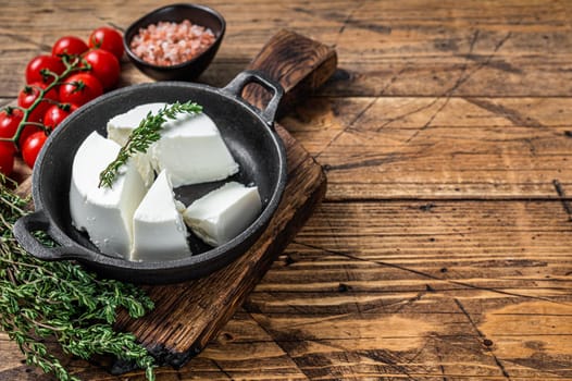 Fresh Ricotta cream Cheese in a pan with basil and tomato. wooden background. Top view. Copy space.