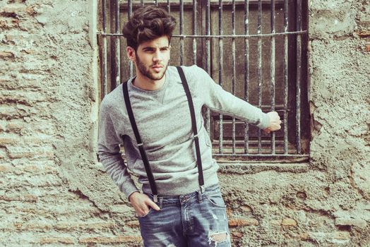 Portrait of young man wearing suspenders in urban background