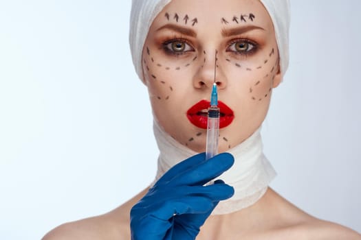 portrait of a woman in blue gloves syringe in hands contour on the face lifting studio lifestyle. High quality photo