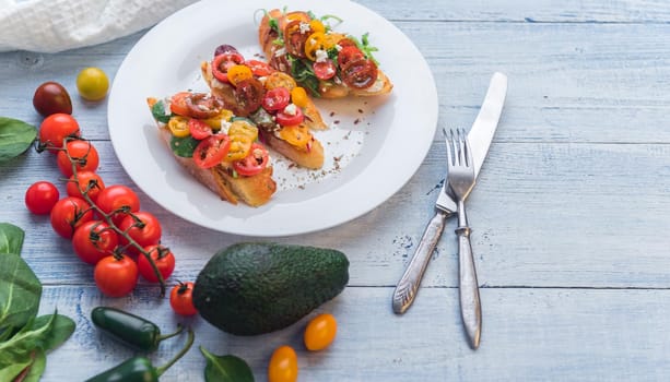 Bruschetta with cheese, basil, arugula and cherry tomatoes