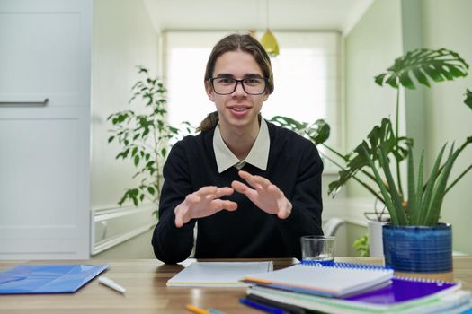 Male teenager talking looking at camera using video communication. Student 15, 16 years old, close-up face, studying remotely at home. E-education, online learning, video lesson, technology, school