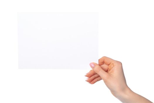 Woman's hand holding blank white sheet of paper isolated on white background