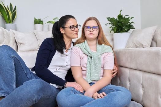 Portrait of happy mom and daughter, mother hugging her teenage daughter, sitting at home together. Mother's day, love, relationship, family concept