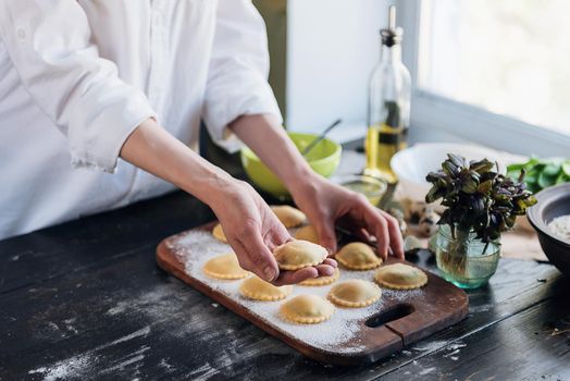 Step by step the chef prepares ravioli with ricotta cheese, yolks quail eggs and spinach with spices. The chef prepares to cook ravioli