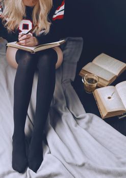 long and slender legs in black Golf American student with books and tea on the floor