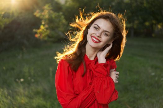 cheerful woman in a red dress in a field outdoors fresh air. High quality photo