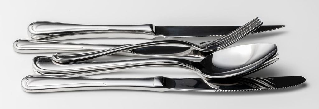 Set of silver cutlery on a white background. Close up.