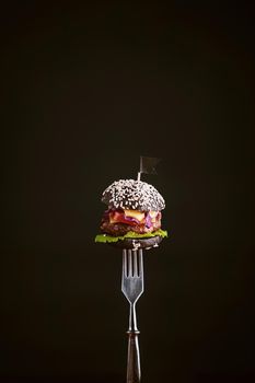 Black mini burger on the fork