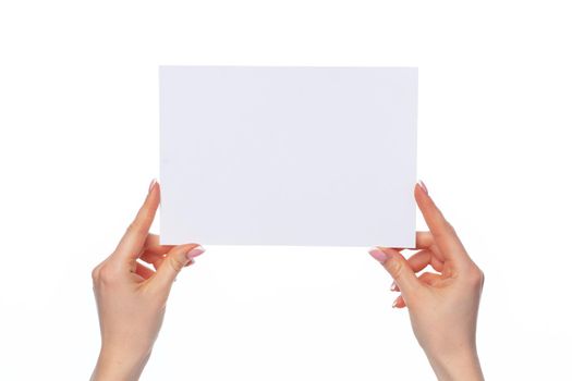 Female hand holding blank white sheet of paper isolated on white background