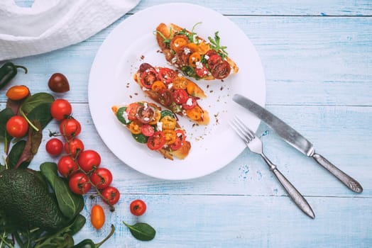 Bruschetta with cheese, basil, arugula and cherry tomatoes