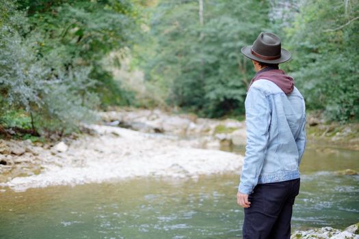 Traveler young man walking by the river in summer.