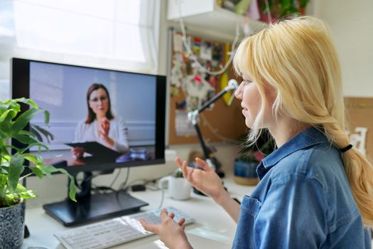 Online consultation of female teenager by social worker psychologist teacher. Virtual meeting, using video call on home computer. Technologies, communication, help, mental health of adolescents