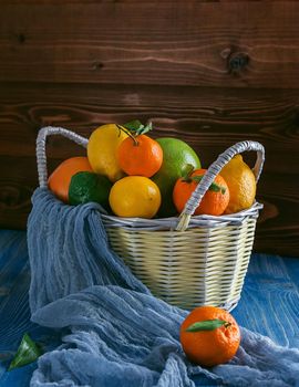 citrus fruits in a wicker basket on a wooden background