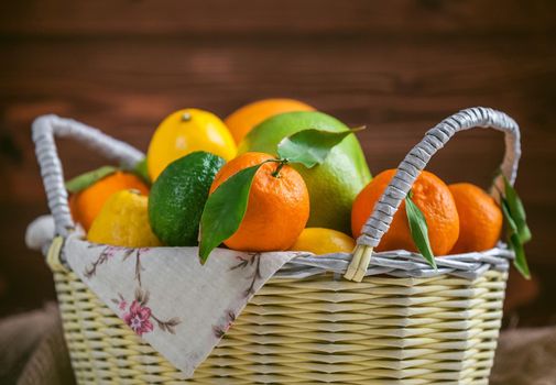 citrus fruits in a wicker basket on a wooden background