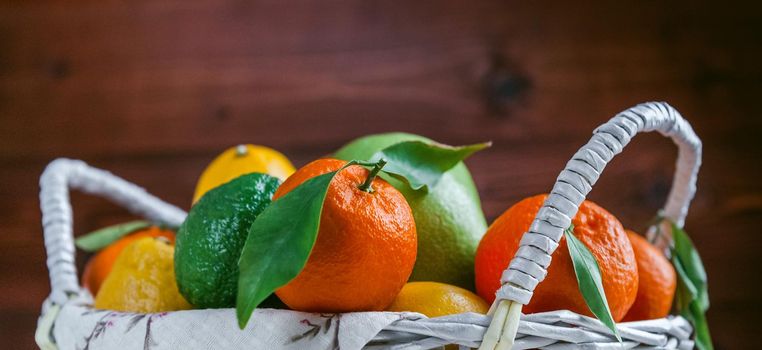 citrus fruits in a wicker basket on a wooden background