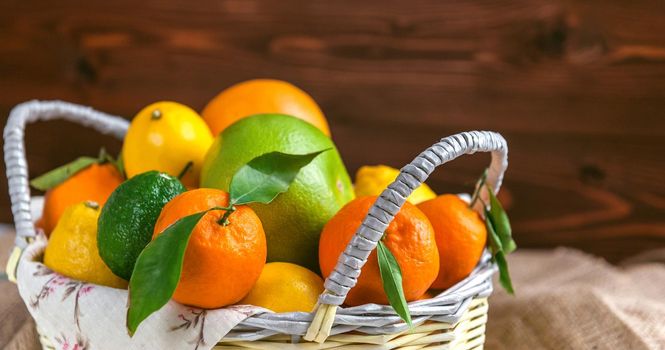 citrus fruits in a wicker basket on a wooden background