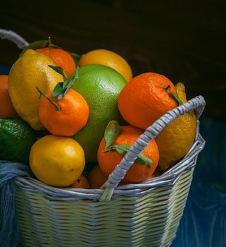 citrus fruits in a wicker basket on a wooden background