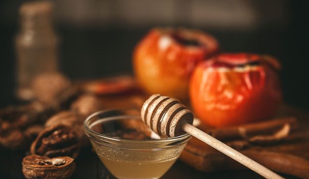 baked apples with cottage cheese with berries and nuts, topped with honey and sprinkled with cinnamon. on a wooden surface in a rustic style