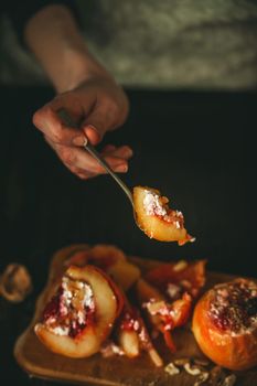 baked apples with cottage cheese with berries and nuts, topped with honey and sprinkled with cinnamon. on a wooden surface in a rustic style